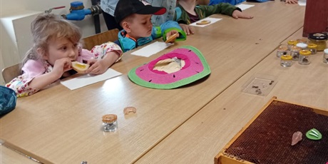 Powiększ grafikę: Dzieci częśtują się chlebem z miodem. Miód zrobiły pszczoły z pasieki w Bolesławowie
