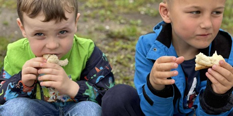 Powiększ grafikę: Chłopcy jedzą kanapki. Na wycieczce wszystko lepiej smakuje